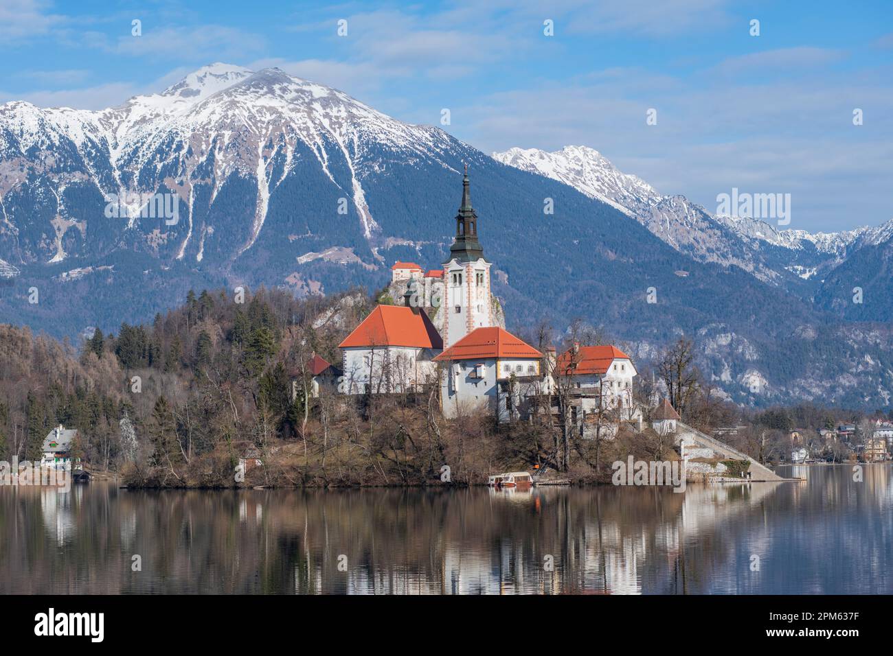 Bleder See: Kirche der Mutter Gottes und Schloss Bled, mit schneebedeckten Bergen im Hintergrund. Slowenien Stockfoto