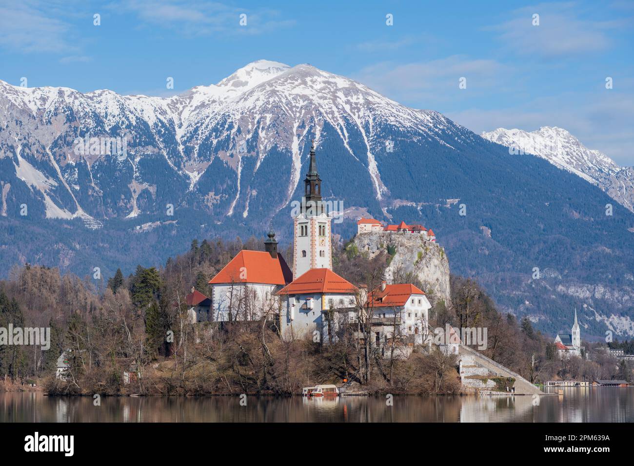 Bleder See: Kirche der Mutter Gottes und Schloss Bled, mit schneebedeckten Bergen im Hintergrund. Slowenien Stockfoto