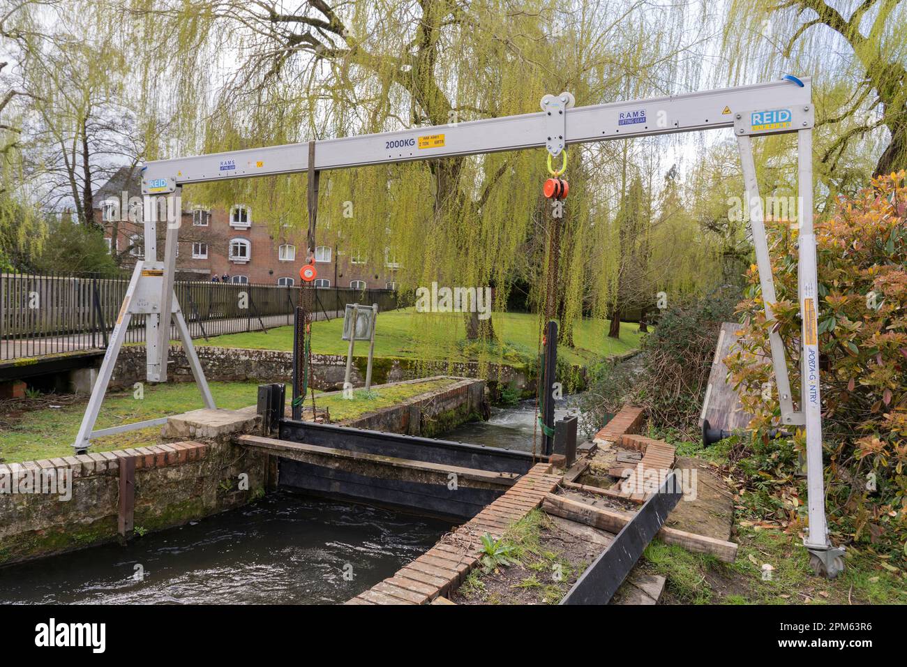Flusssteuerung – ein manuell einstellbares Schleusentor, das von einer Reid A-Frame-Gantry und einem flussabwärts gelegenen Wehr auf dem Fluss Itchen gehalten wird. Winchester, England Stockfoto