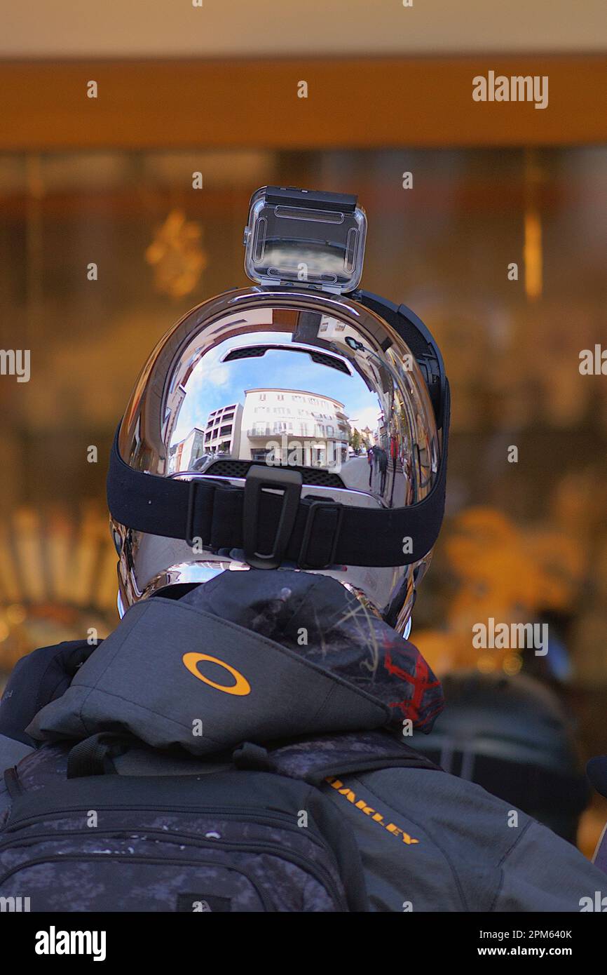 Rückansicht einer Person, die einen silbernen Helm mit Action-Kamera-Halterung trägt. Stockfoto