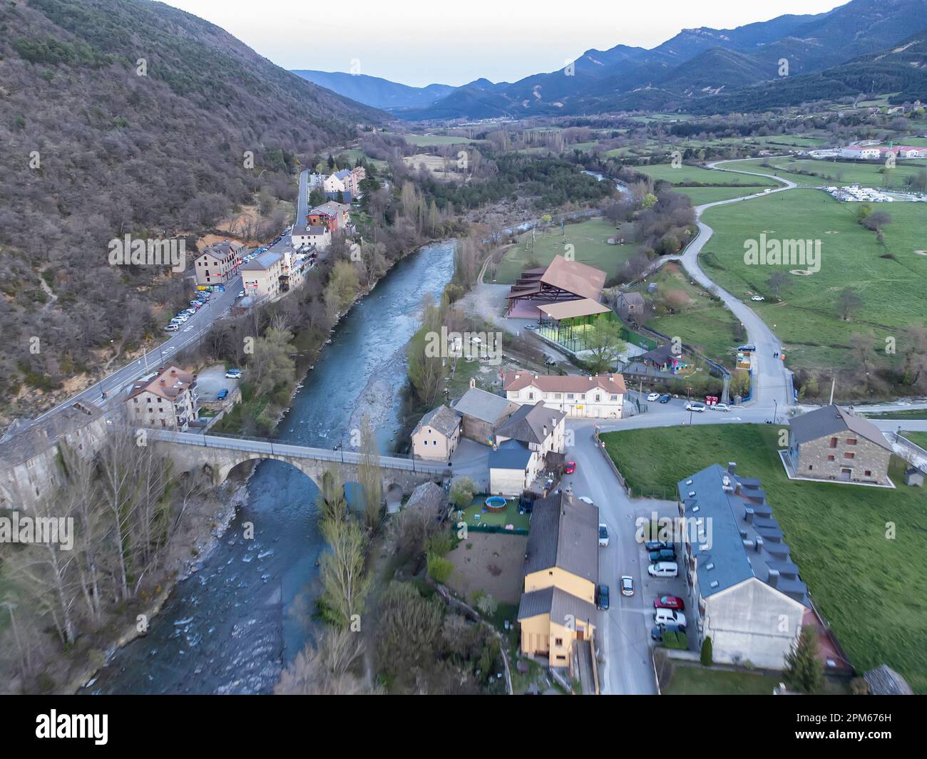 Fluss Ara, der durch das Dorf Fiscal in den Aragonesischen Pyrenäen fließt, im Vordergrund die Brücke, die den Zugang zum Dorf von der Straße aus ermöglicht, Mount Stockfoto