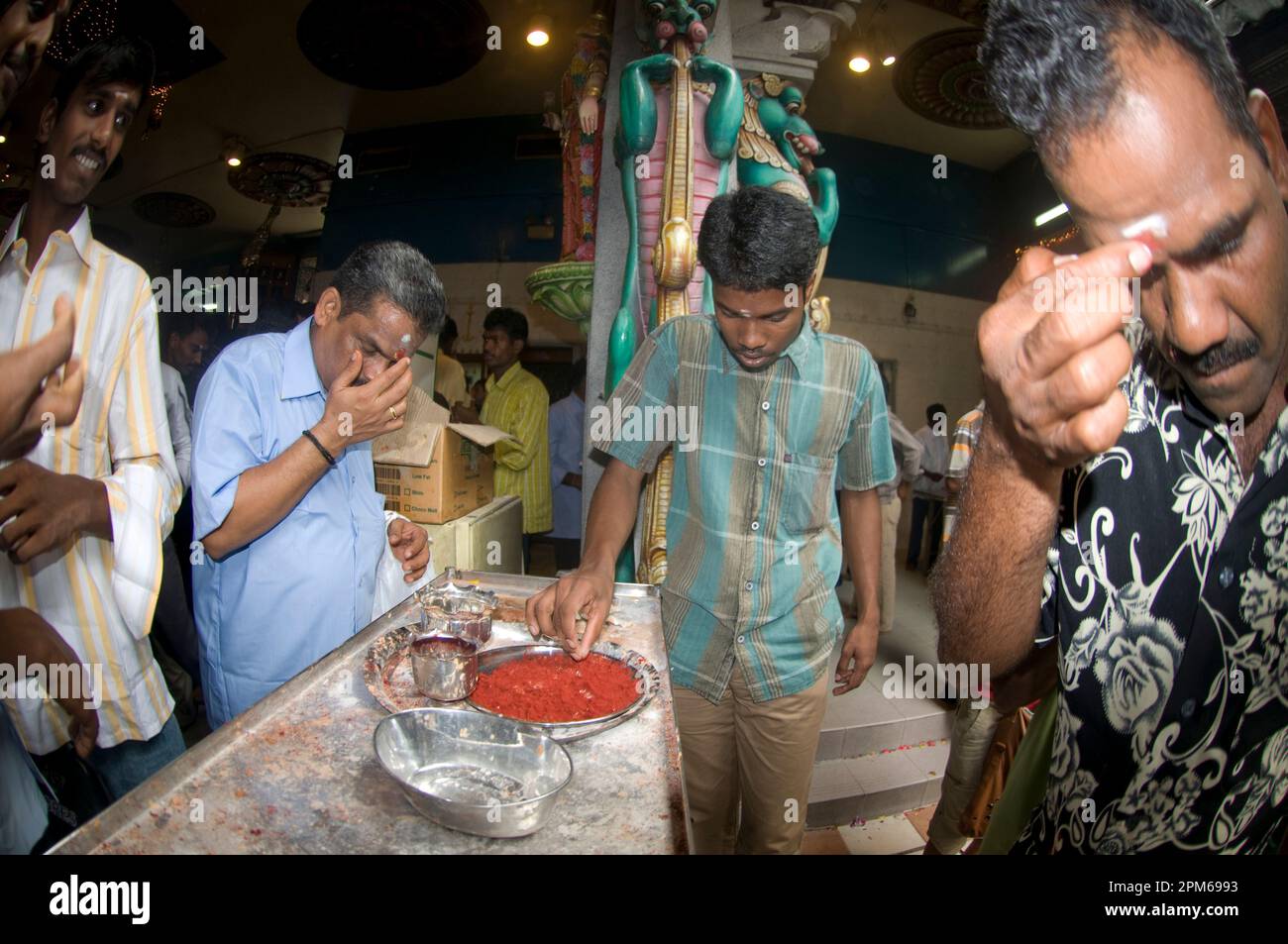 Männliche Anhänger, die bei der Deepavali-Zeremonie weißes Bindi auftragen, Sri Veeramakaliamman-Tempel, Little India, Singapur Stockfoto