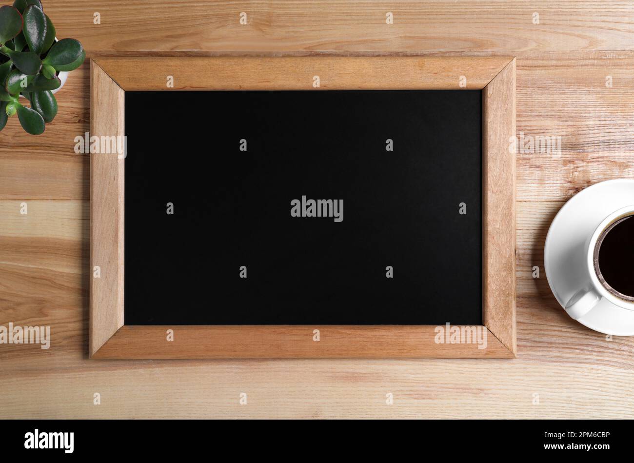 Kleine Tafel, Kaffee und Pflanze auf Holztisch reinigen, flach ablegen Stockfoto