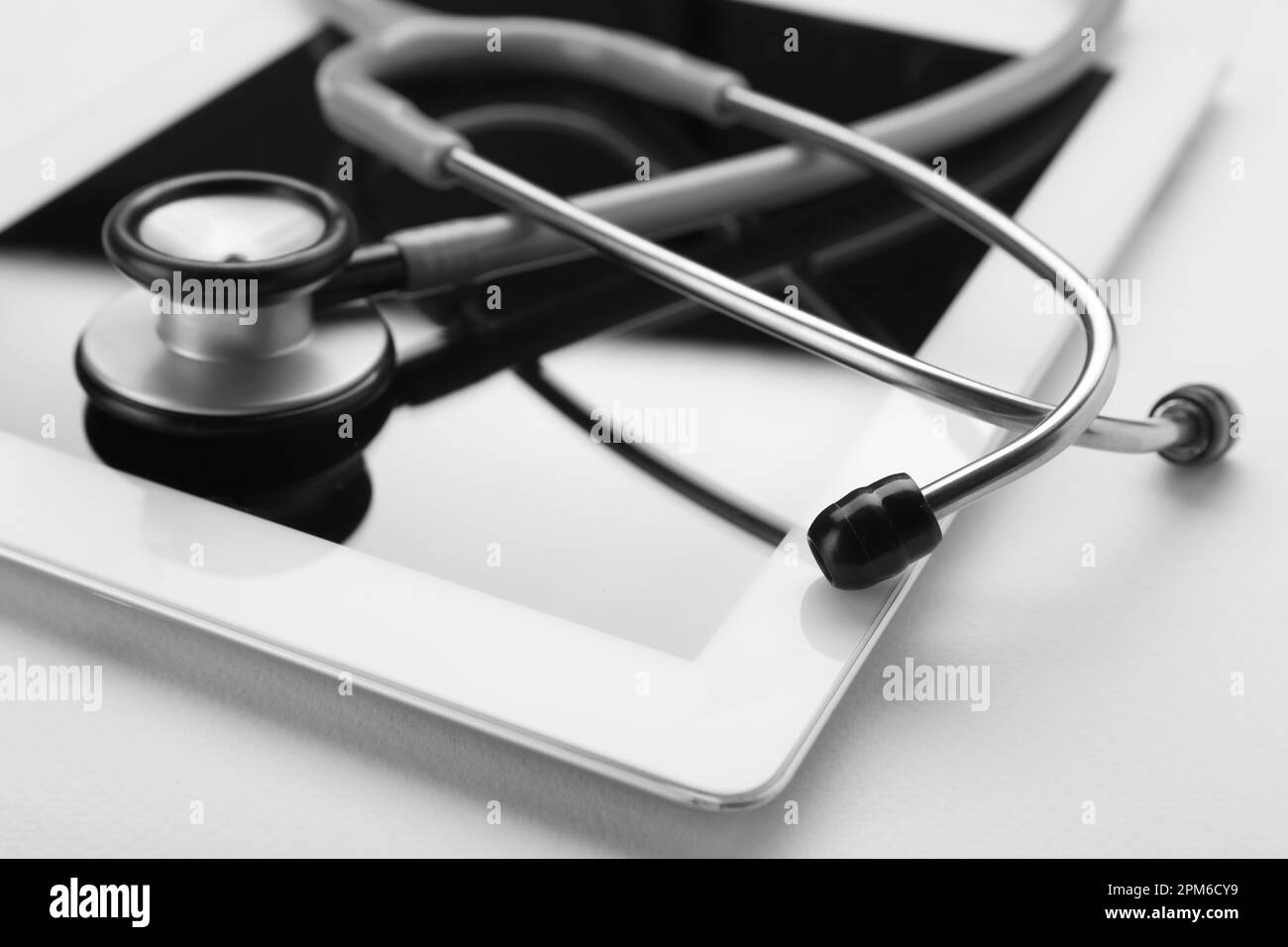Medizinisches Stethoskop und Tablet auf beigefarbenem Hintergrund, Nahaufnahme Stockfoto