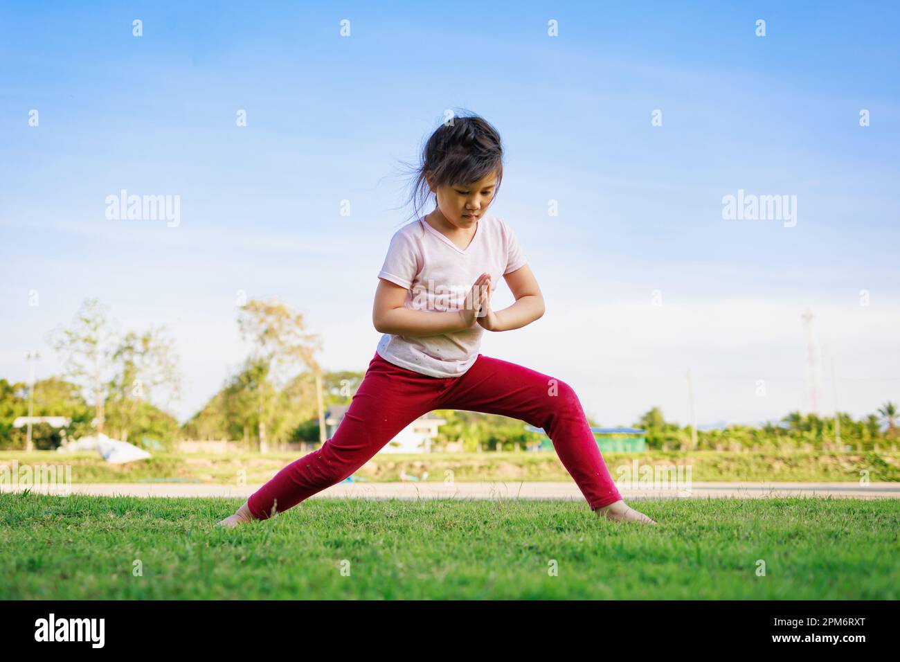 Kindermeditation mit Yoga-Pose auf grünem Grasfeld. Aktivitäten im Freien für Kinder, Yoga-Übungen, Kinder können lernen, wie man trainiert. Stockfoto