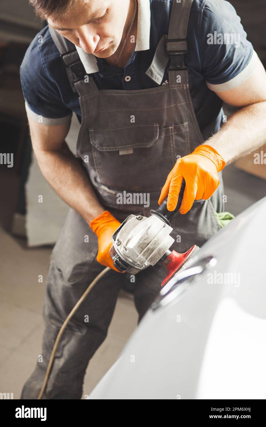 Autoverstückungsserie: Polieren weißer Fahrzeuge in der Autoherstellung. Stockfoto