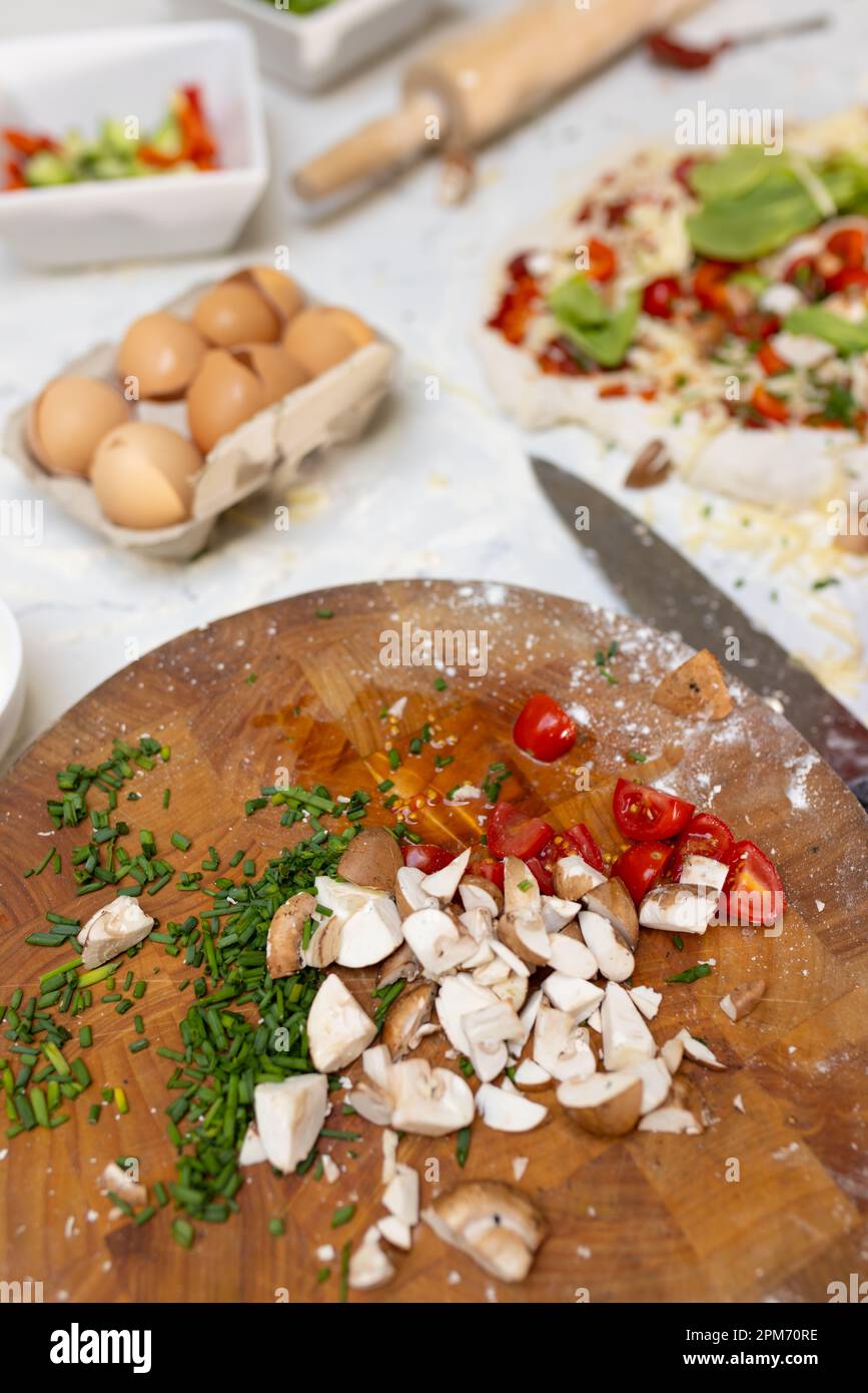 Nahaufnahme von Lebensmittelzutaten und Pizza auf der Arbeitsfläche in der Küche Stockfoto