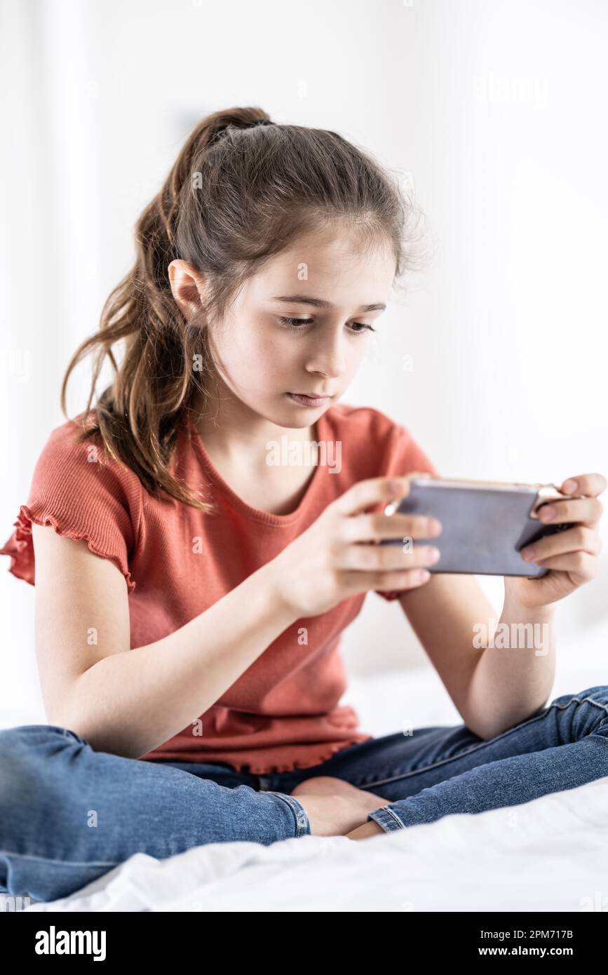 Kinder im Teenageralter sind süchtig danach, online zu sein, fomo zu haben und ihr Handy immer in der Hand zu haben. Stockfoto