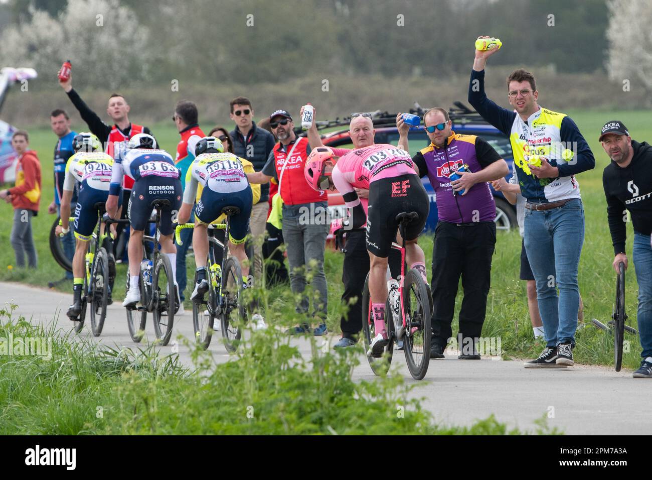 Team-Seeleute, die ihren Reitern in Patis-Roubaix Flaschen geben Stockfoto