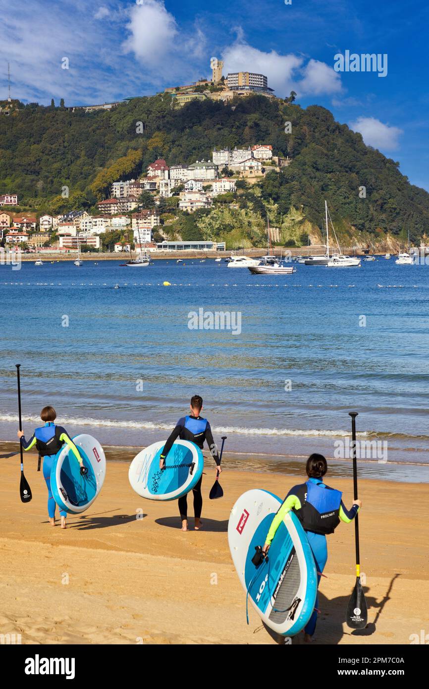 Gruppe von Touristen, die Paddelsurfen in La Concha Bay, SUP, Stand Up Paddle, Donostia, San Sebastian, Pais Vasco, Spanien Stockfoto