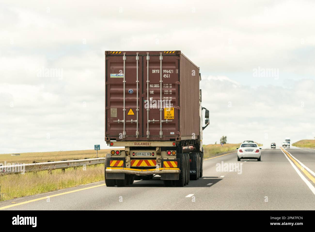 Versandcontainer als Transport im Schwerlastwagen auf einer Autobahn in Südafrika Konzepthandel und Logistik Stockfoto