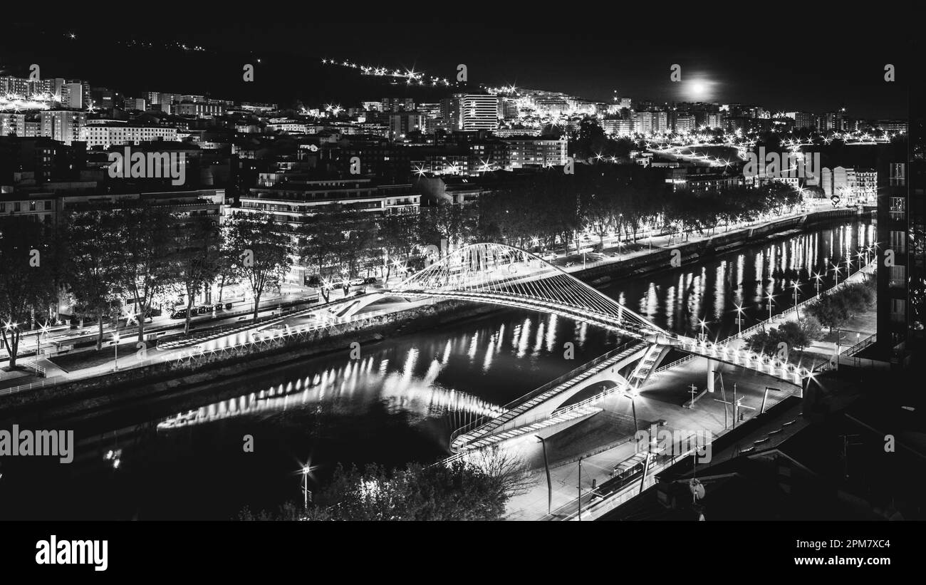 Bilbao Stadtbild und Fußgängerbrücke zubizuri bei Nacht, Bilbao, Baskenland, Spanien in Monochrom Stockfoto