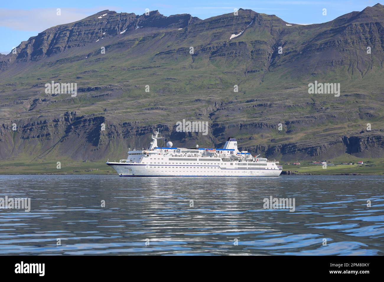 Das kleine klassische Kreuzfahrtschiff MS Berlin (heute Traumgöttin) vor Anker in der Nähe der Berge von Djúpivogur, Island, Vintage-klassische Passagierschiffe Bild Stockfoto