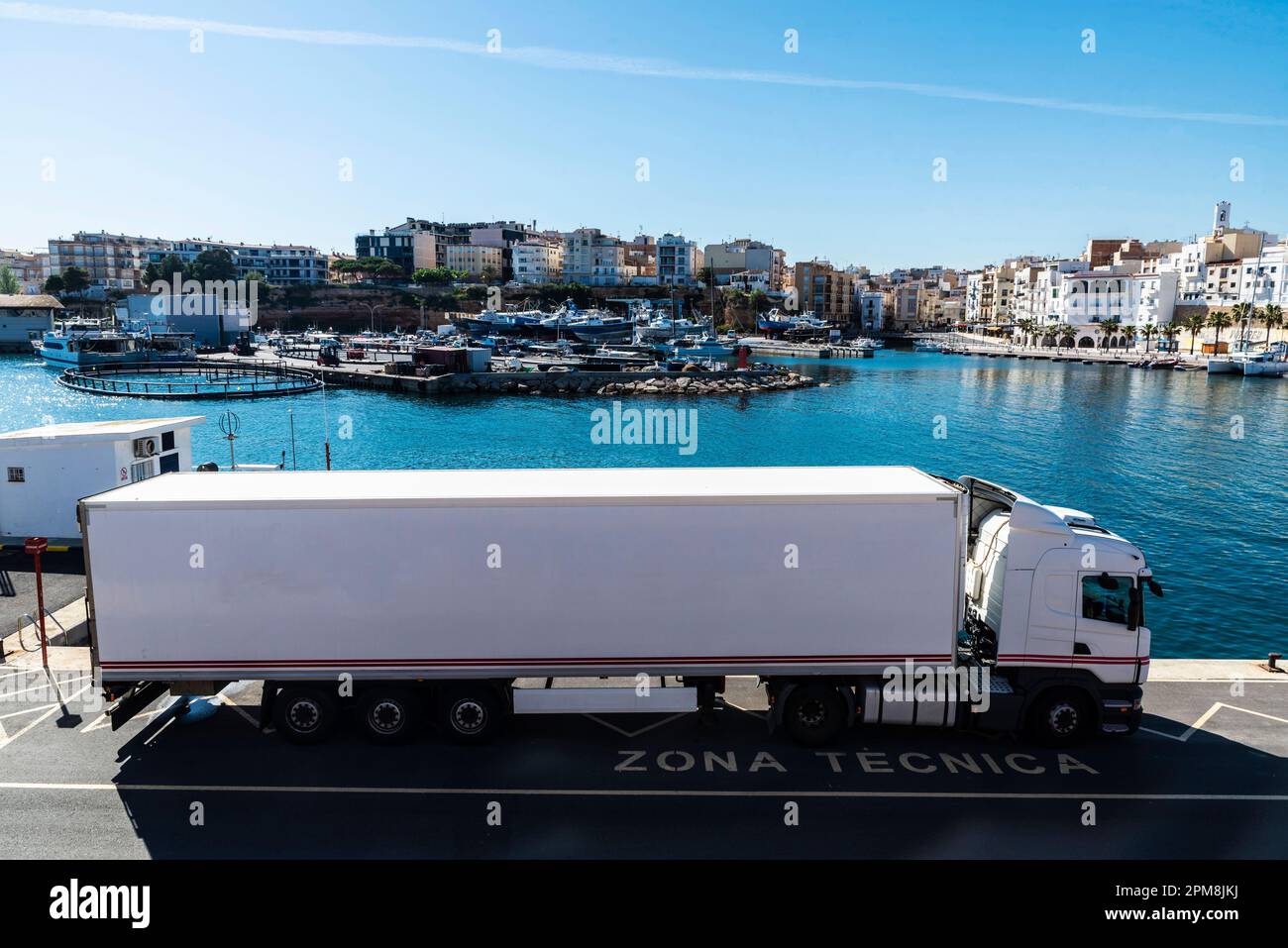 Weißer Lastwagen parkt im Hafen von Ametlla de Mar, Tarragona, Katalonien, Spanien Stockfoto