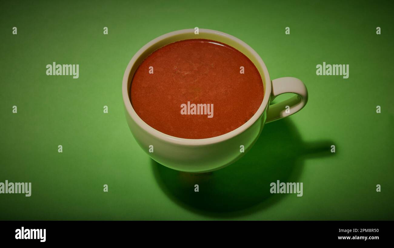 Tasse heiße Schokolade isoliert auf grünem Hintergrund. Stockfoto