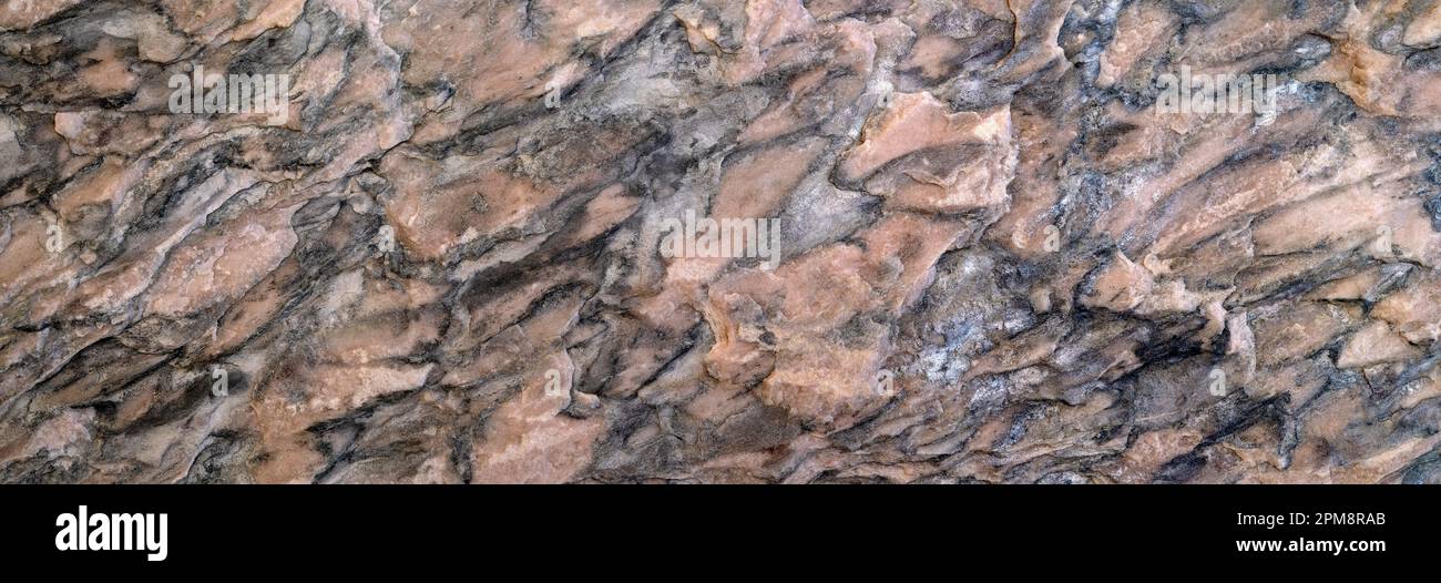Abstraktes Muster in Braun, Grau und Schwarz auf einer rauen Steinoberfläche Stockfoto