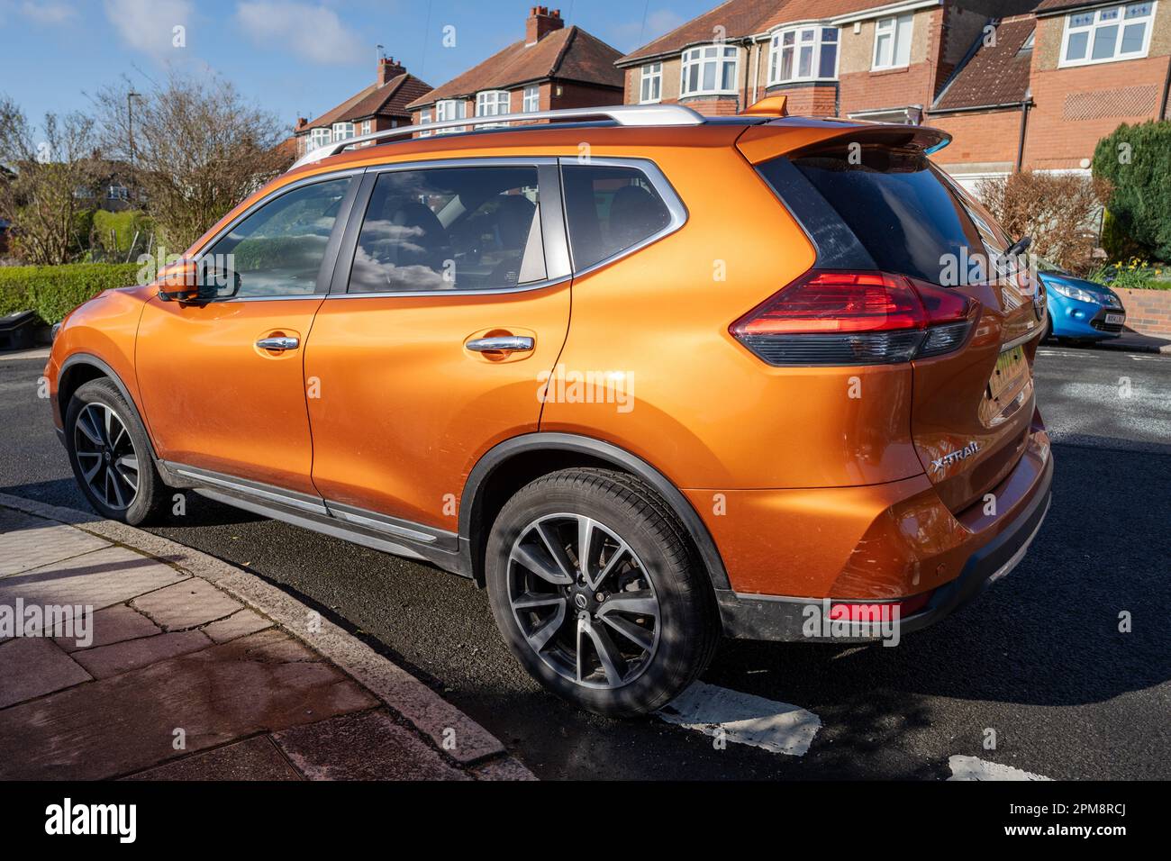 Ein orangefarbenes Nissan X-Trail Auto parkt in der Vorstadt. Stockfoto