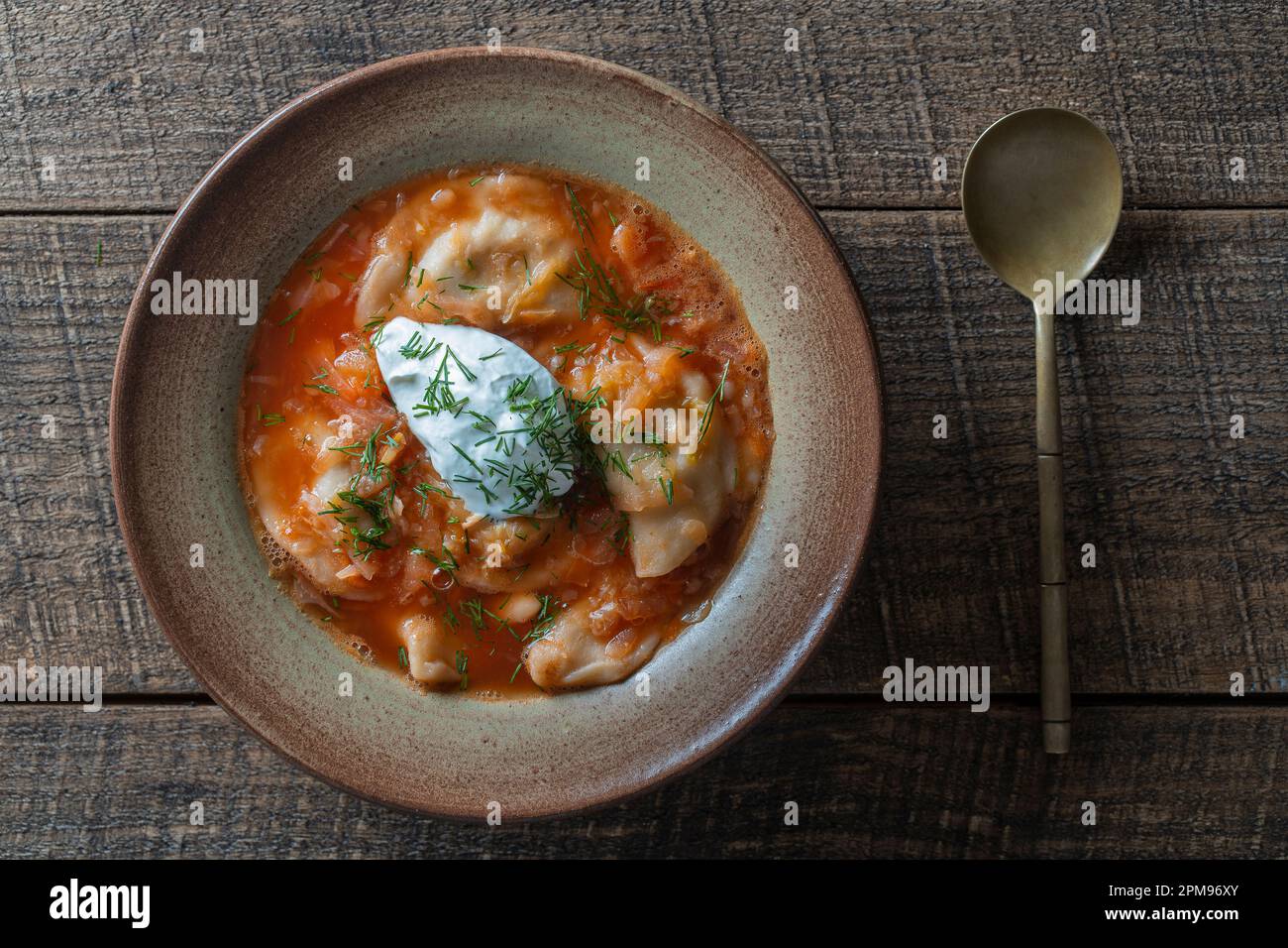 Ukrainisches Nationalgericht Rot Borscht mit Knödeln in einer Keramikplatte auf Holzhintergrund. Rote-Bete-Suppe ist ein Nationalgericht in der Ukraine, aus der Nähe, t Stockfoto