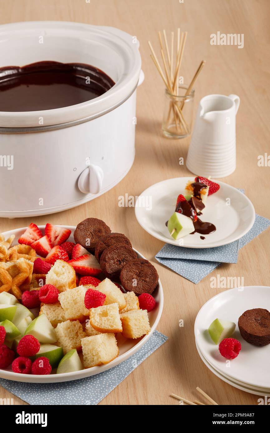 Slow-Cooker-Schokoladen-Fondue mit Obst und Waffeln Stockfoto