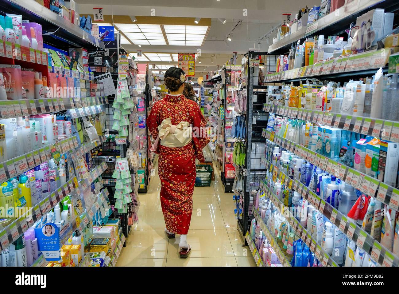 Kyoto, Japan - 31. März 2023: Eine Frau, die in einem Kimono gekleidet ist und in einem Supermarkt im Stadtteil Gion in Kyoto, Japan, einkauft. Stockfoto