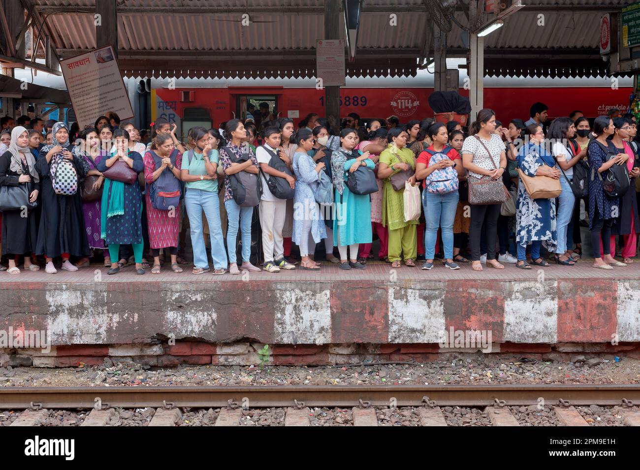 Eine Menge weiblicher Pendler, die einen Bahnsteig an der Dadar Station in Mumbai, Indien, überquert haben und darauf warten, an Bord eines der Damen-Spezial-Drehgestelle zu gehen Stockfoto