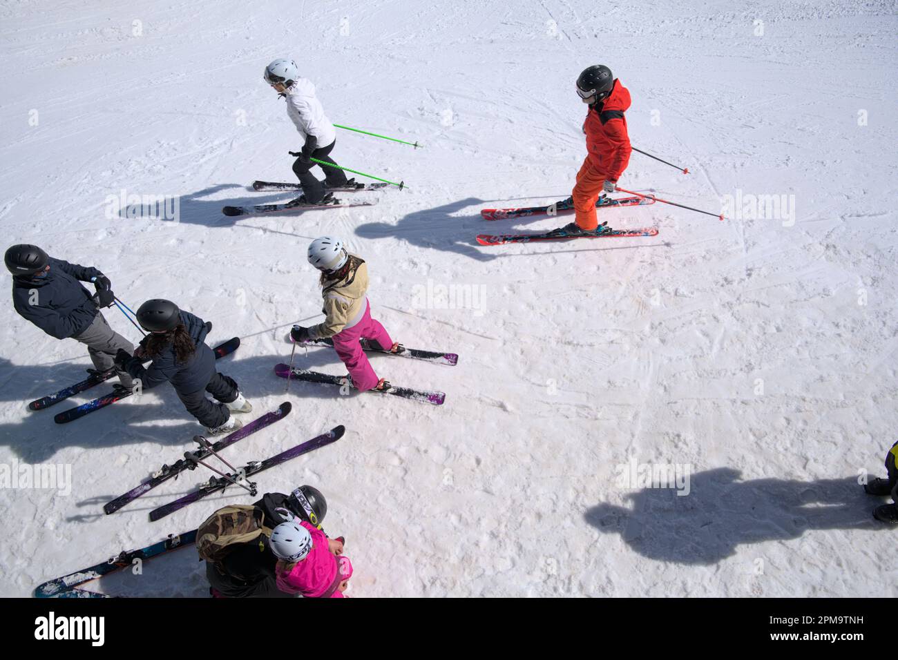 Eine Gruppe von Freunden macht sich bereit für den Abstieg in Les Diablerets in den Schweizer Alpen, ein Kopfschuss von Skifahrern Stockfoto