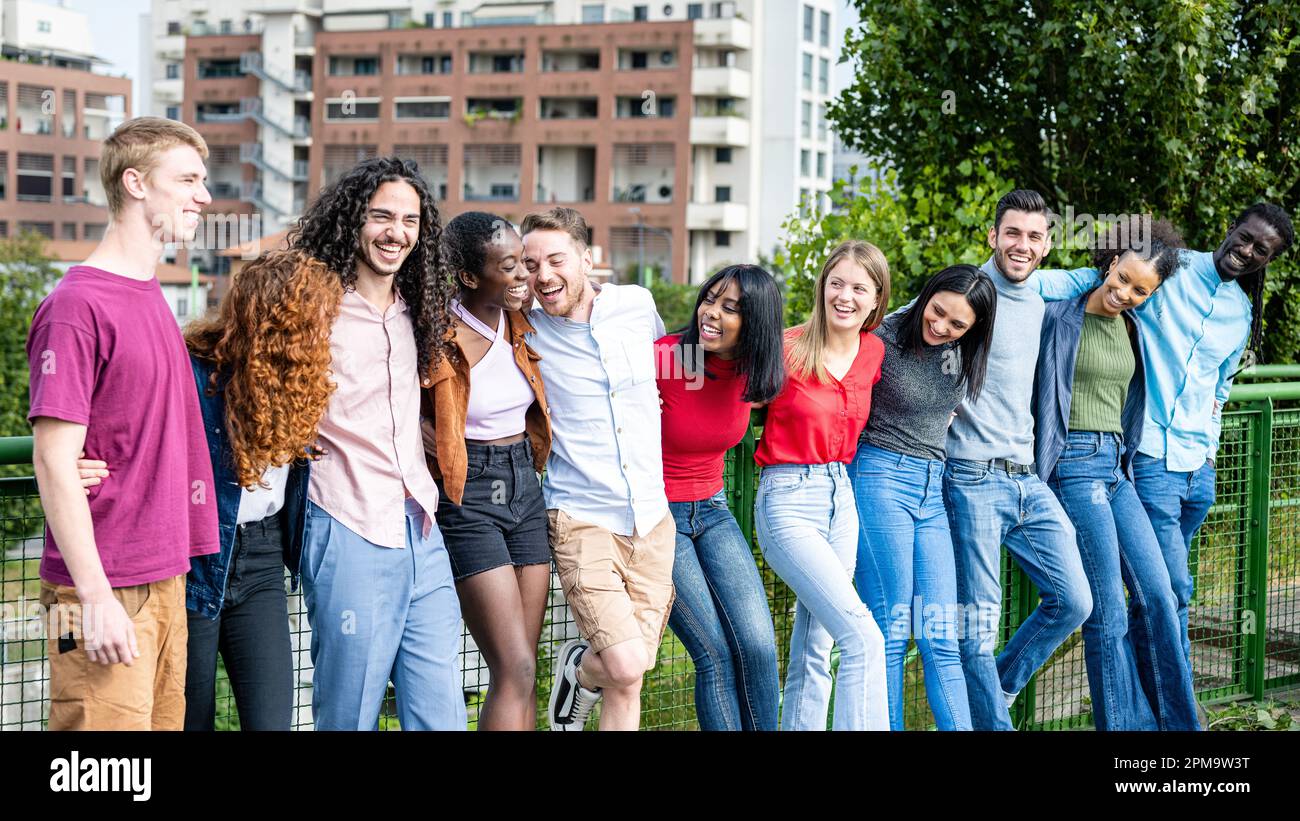 Glückliche Gruppe von multirassischen jungen Freunden, vielfältige Leute, die draußen vor der Kamera lächeln, internationale Gemeinschaft und fröhliche Menschen Stockfoto
