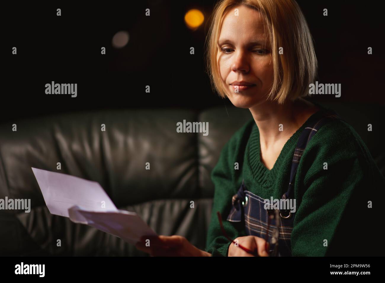 Schlechte Nachrichten in einem Brief. Die Frau ist schockiert über den Inhalt des Briefes. Schulden, schlechte Nachrichten. Stockfoto