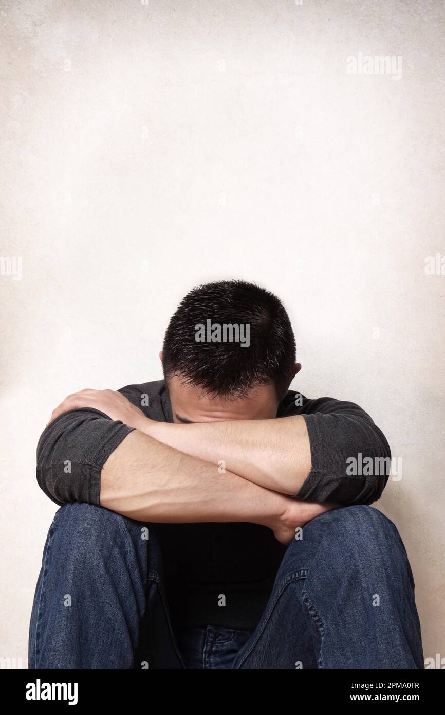 Depression traurige junge Mann sein Gesicht verbergen Stockfoto