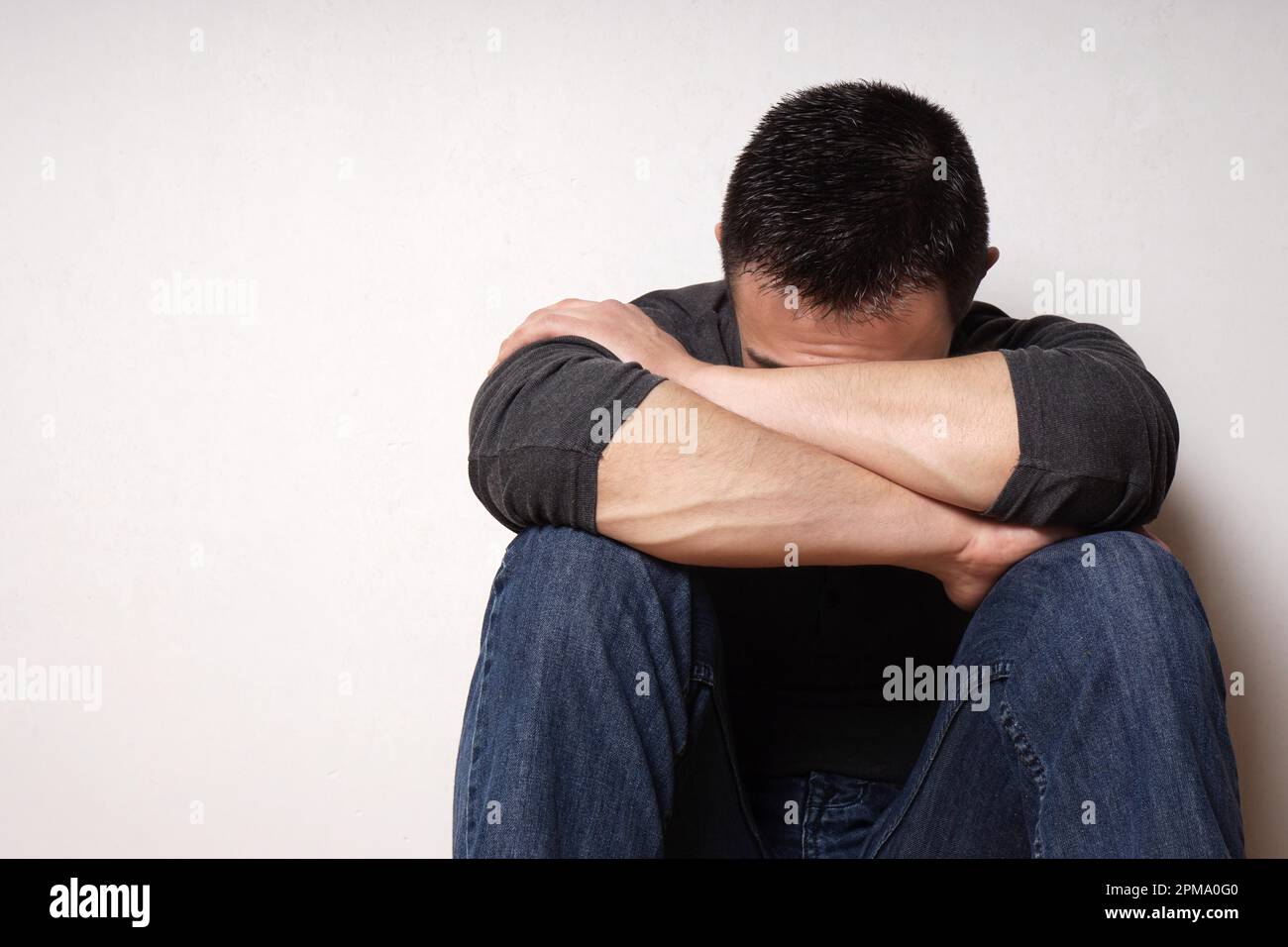 Deprimiert gebrochenes Herz junger Mann sein Gesicht verbergen Stockfoto