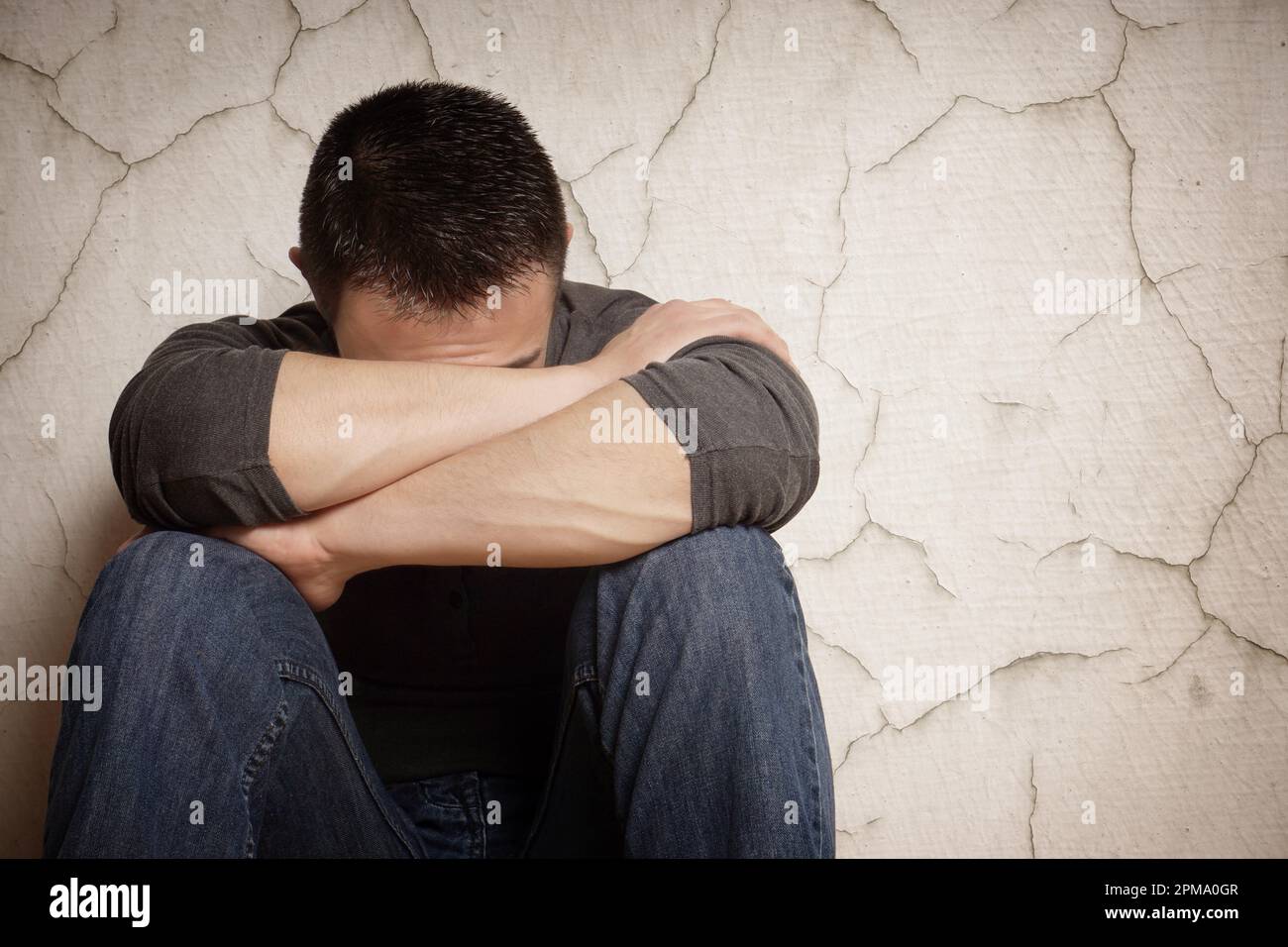 Depression verwüstet junger Mann sein Gesicht verbergen Stockfoto