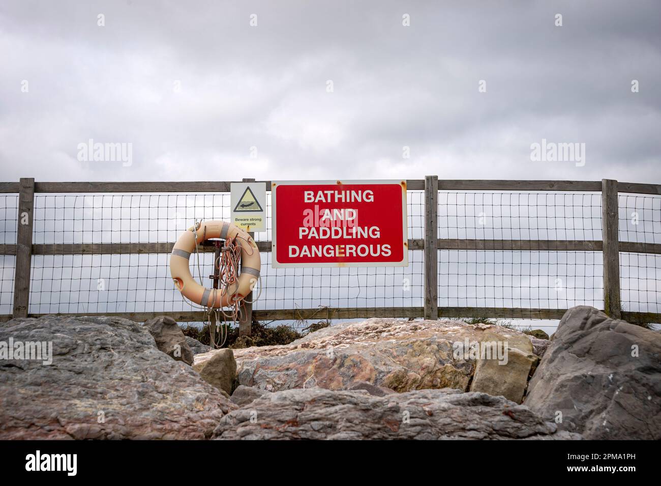 "Baden und Paddeln gefährlich" -Schild mit Rettungsboot Stockfoto