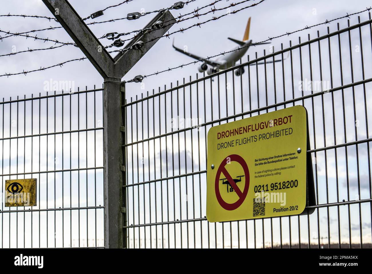 Internationaler Flughafen Düsseldorf, Sicherheitszaun an der Flughafengrenze, Start- und Landebahn, Hinweis auf das Verbot von Drohnenflügen auf Flughäfen, Flugzeuge auf App Stockfoto