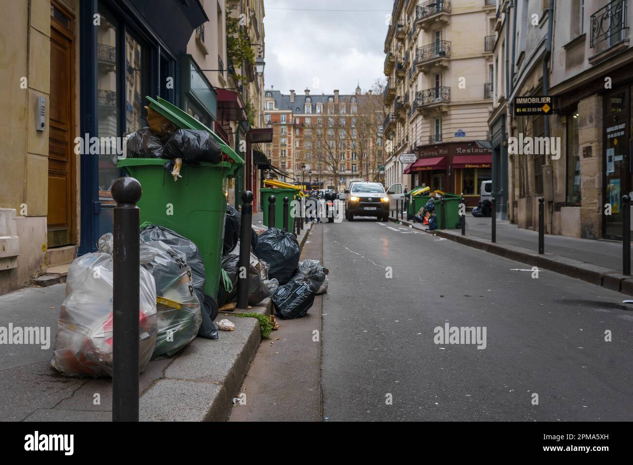 Überfließende Mülltonnen auf der Straße von Paris, Frankreich während des Rentenreformstreiks. 24. März 2023. Stockfoto