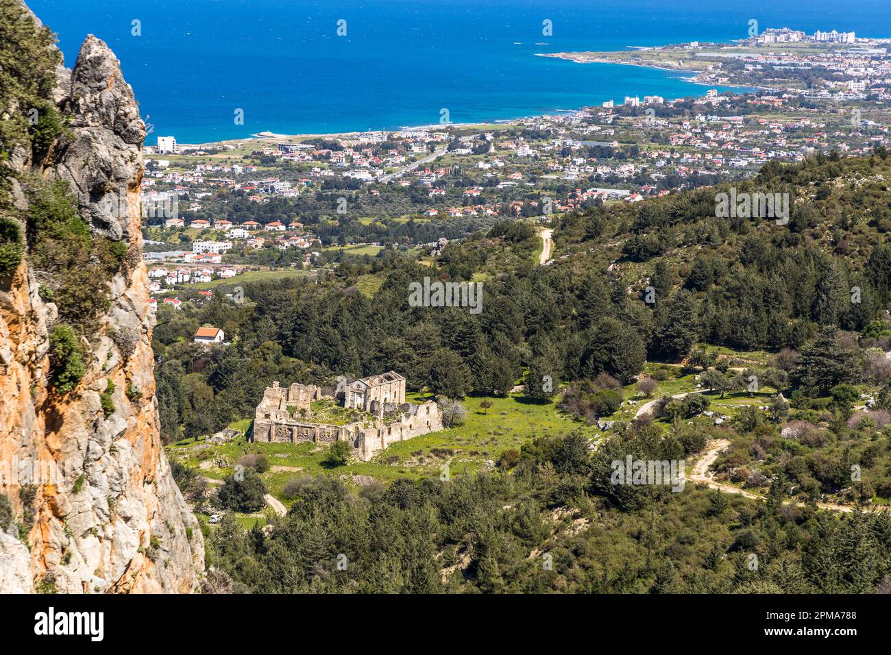 Kloster Tarihi Manastır auf dem Wanderweg von Karmin nach St. Hilarion. Blick vom Beşparmak Trail Five Finger Mountains im Norden Zyperns auf Klosterruinen und die Stadt Girne/Kyrenia Stockfoto