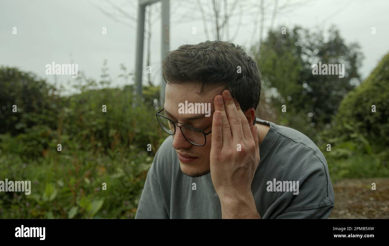 Ein gutaussehender Mann mit Brille, der Schmerzen hat, kämpft mit einem plötzlichen Auftreten von Gesundheitsproblemen Stockfoto