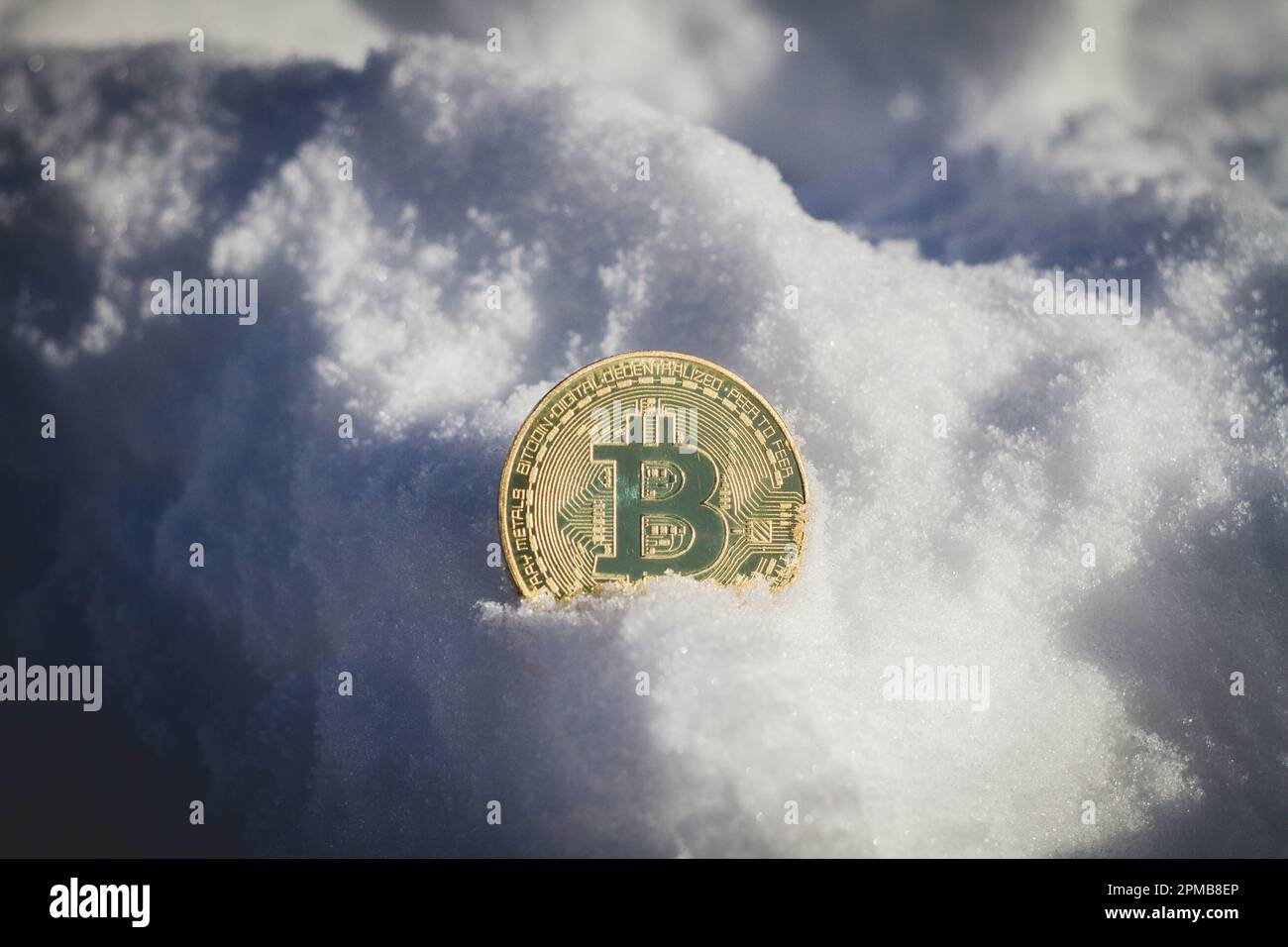 Bitcoin-Münze im Schnee. Konten sperren. Blockierung von Kryptowährungen... Stockfoto