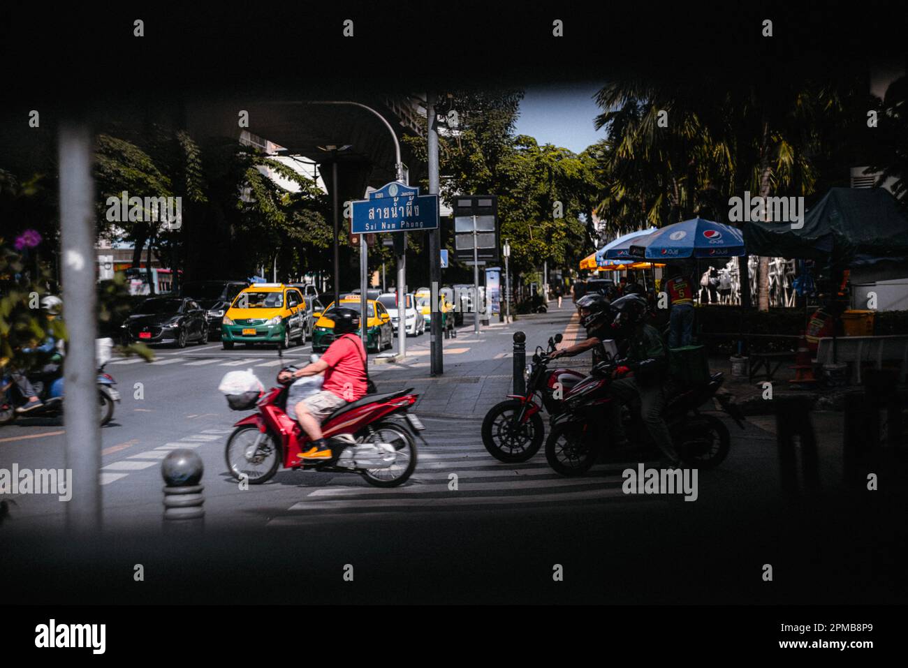 Die asiatische Metropole Bangkok wurde mit Motorrädern, Autos, Taxis und vielen Menschen, die sich im Chaos der Großstadt bewegen, erschossen Stockfoto