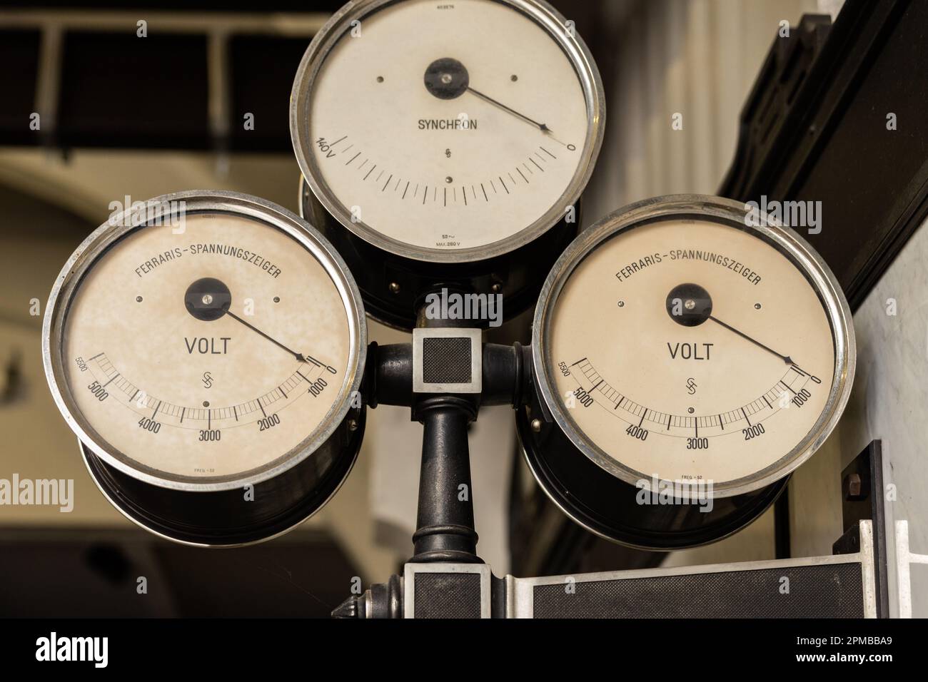 Alte Elektrogeräte werden auf einem Hängestänge in einem alten Kraftwerk befestigt Stockfoto