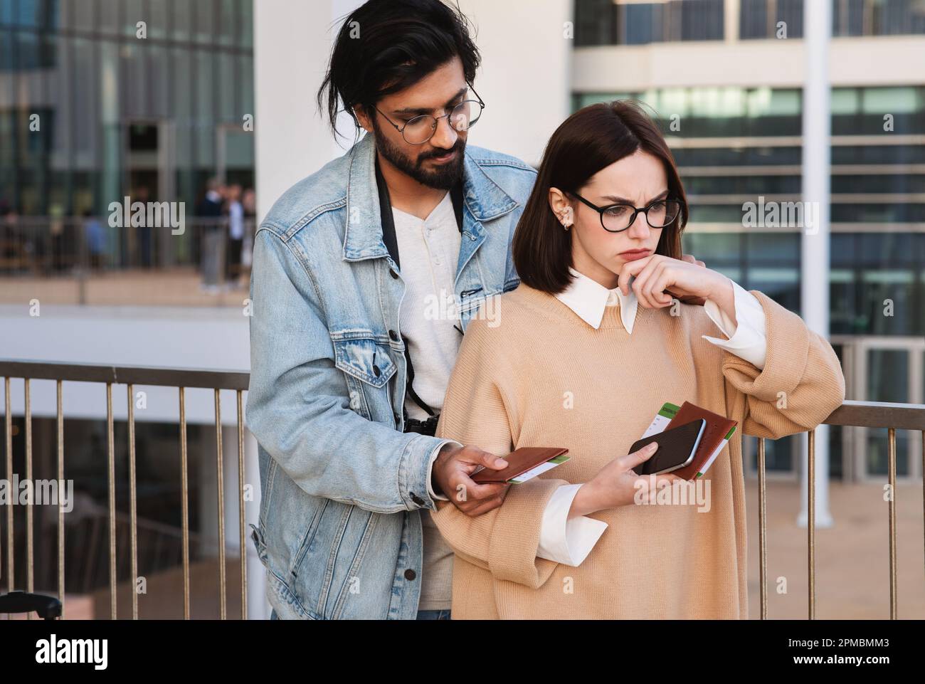 Der traurige Millennials-indianer beruhigt sich, beleidigt weiße Touristinnen mit Pässen und Tickets Stockfoto