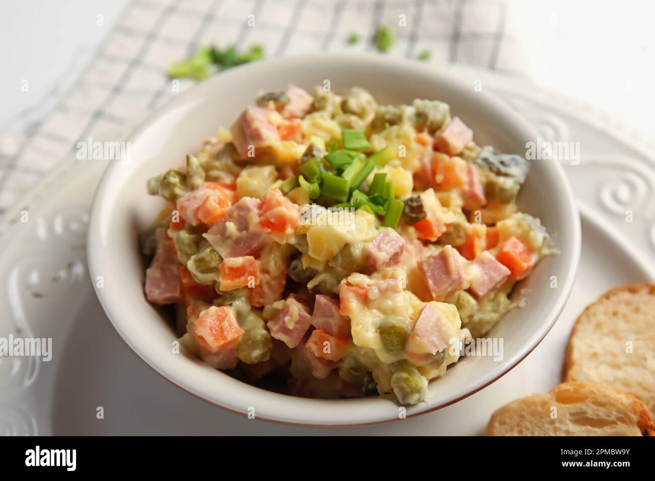 Schüssel mit leckerem Olivier-Salat auf dem Tisch, Nahaufnahme Stockfoto