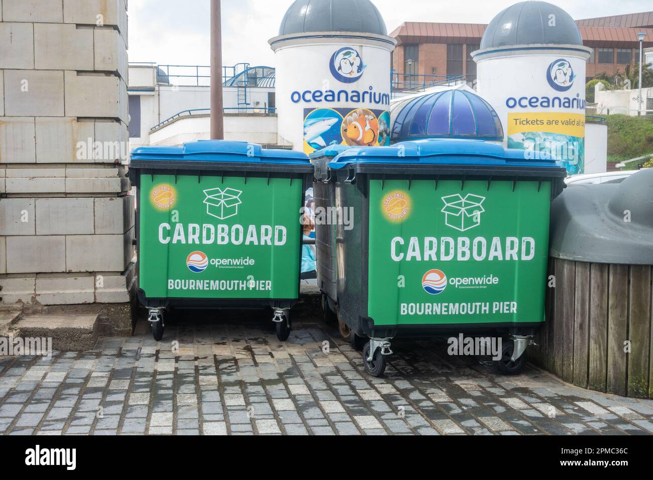 Große, schwarze, kommerzielle Mülltonnen auf dem Bournemouth Pier zum Recycling von Kartonabfällen. Stockfoto