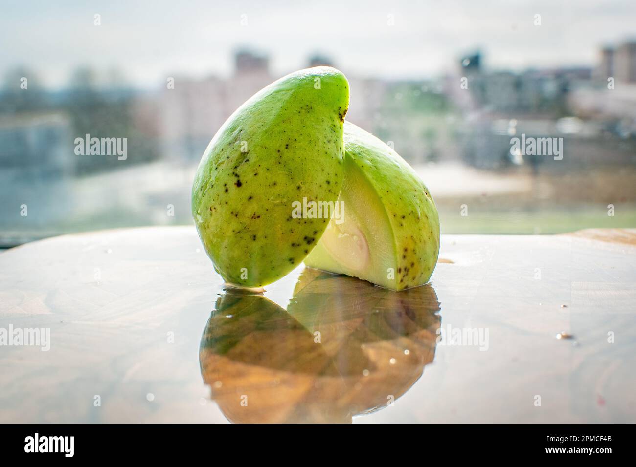 Grüne Mango oder Baby-Mango ist eine kleine runde Mango mit einer leuchtenden smaragdgrünen Farbe. Verwendet, um bei der Gewichtsabnahme und der Gesundheit der Leber zu helfen. Stockfoto