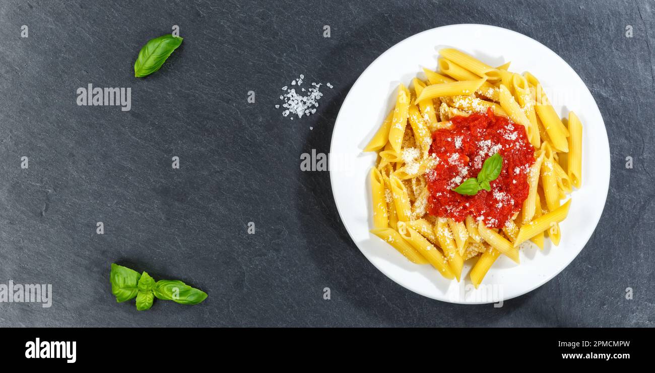 Penne Rigatoni Rigate Pasta Top View Mahlzeit aus Italien Essen Sie zu Mittag mit Tomatensoße Kopier Space Panorama Schiefer auf einem Teller Stockfoto