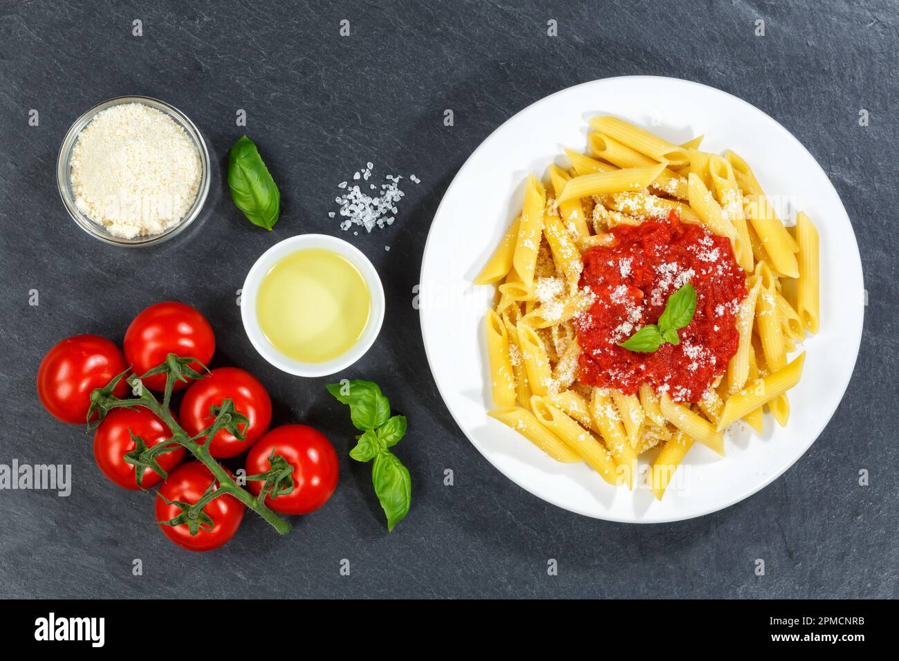 Penne Rigatoni Rigate Pasta Top View aus Italien Essen Sie zu Mittag mit Tomatensoße Schiefer auf einem Teller Stockfoto