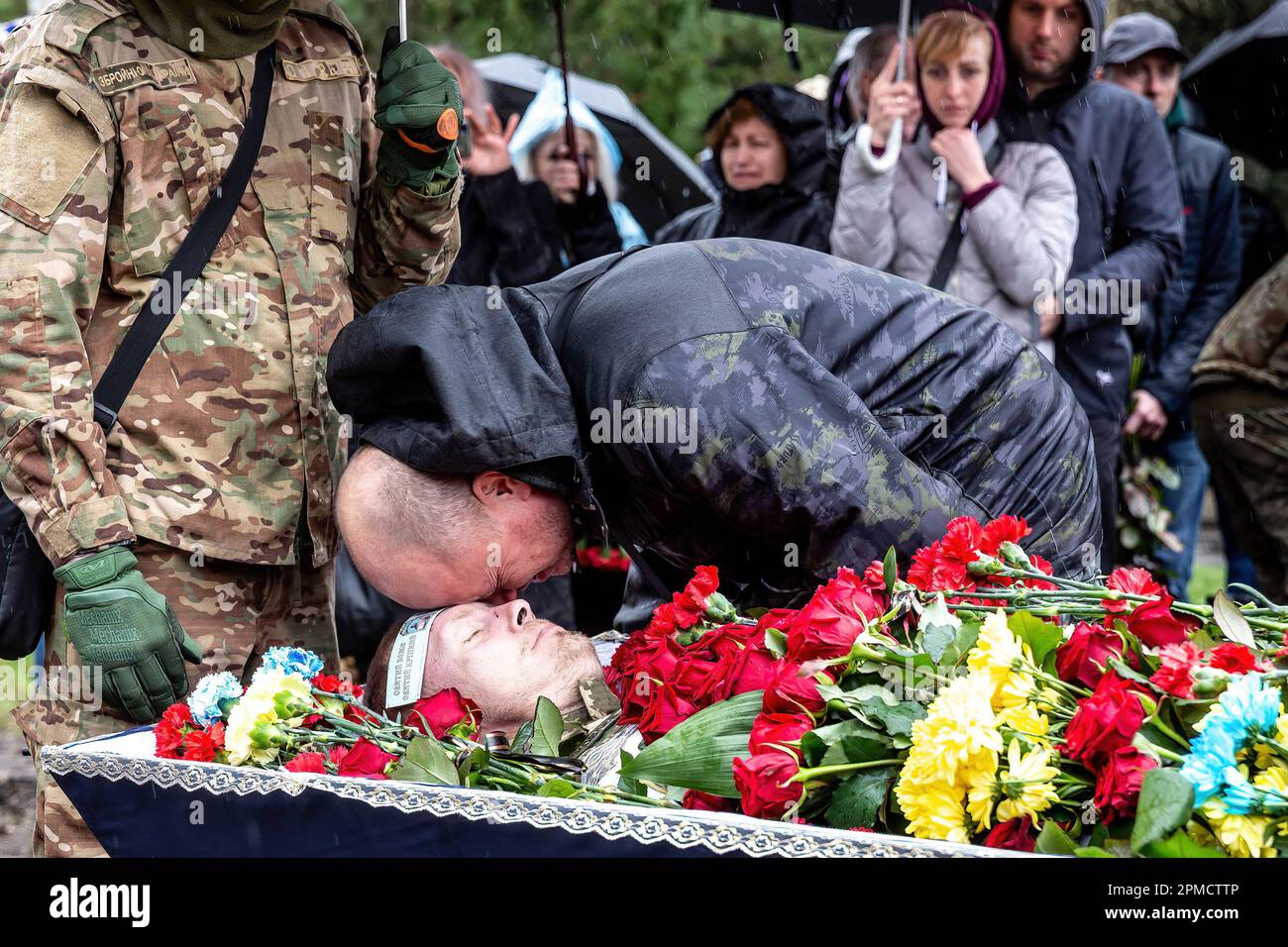 (ANMERKUNG DER REDAKTEURE: Bild zeigt den Tod) Ein Freund schenkt Respekt bei der Beerdigung von Evgeny Yakovlev, 42, einem Soldaten, der von russischen Streitkräften an der Ostukrainischen Front in einem Kampf auf dem Lisove-Friedhof in Kiew getötet wurde. Auf dem Lisove Friedhof sind die meisten der gefallenen Armeeangehörigen aus Kiew begraben. Da die Invasion der Ukraine in vollem Umfang durch die russischen Streitkräfte andauert, verursacht der Kampf im Osten der Ukraine eine sehr hohe Zahl von Opfern, obwohl die genauen Zahlen unbekannt sind. Die Ukraine bereitet sich auf eine Frühjahrsoffensive zur Rückeroberung des von Russland besetzten Landes vor. Stockfoto