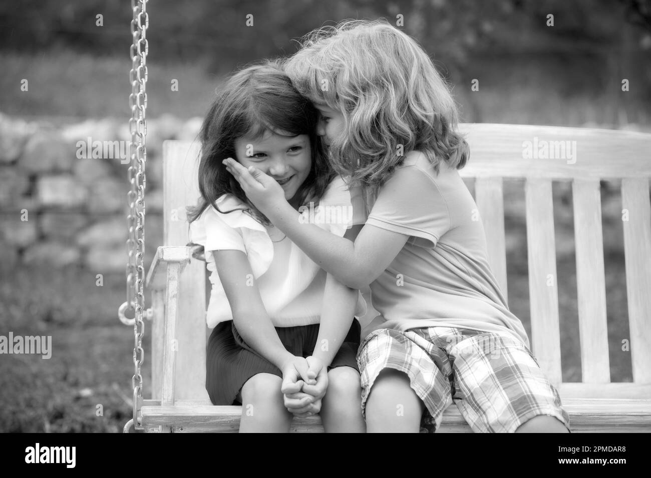 Kinder küssen sich im Sommerpark im Freien. Kleine Jungen und Mädchen Kinder genießen den Sommer. Beste Freunde zwei Kinder. Stockfoto