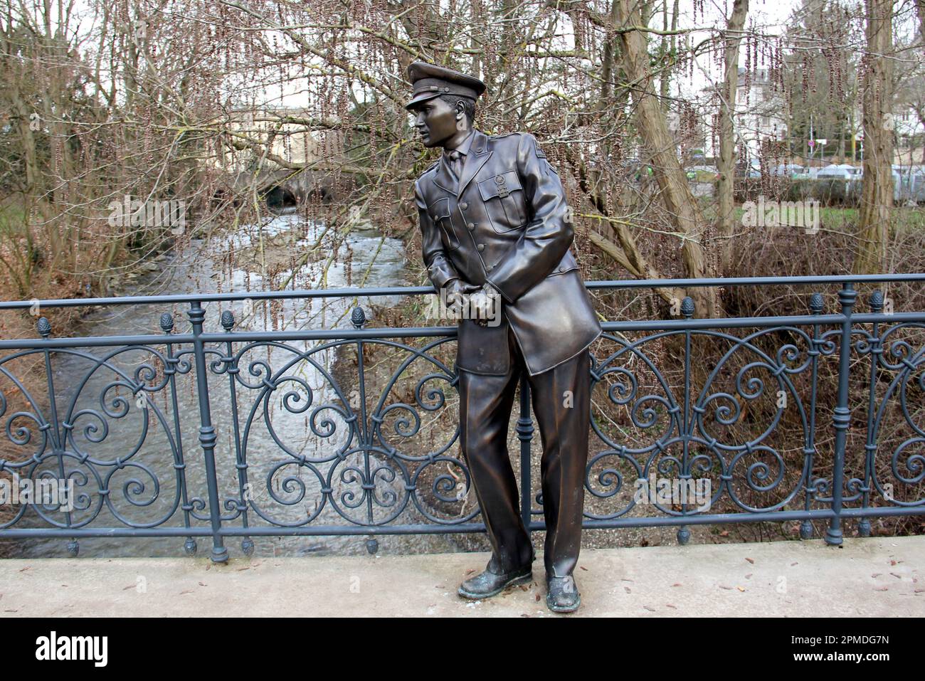 Bronzestatue von Elvis Presley, in US-Armeeuniform, auf der Fußgängerbrücke über den Fluss USA im Kurpark, Bad Nauheim, Deutschland Stockfoto