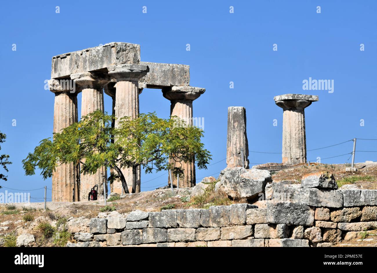 Der antike Apollo-Tempel an der archäologischen Stätte von Korinth und Museum in Korinth Griechenland' an einem sonnigen Tag mit blauem Himmel. Stockfoto