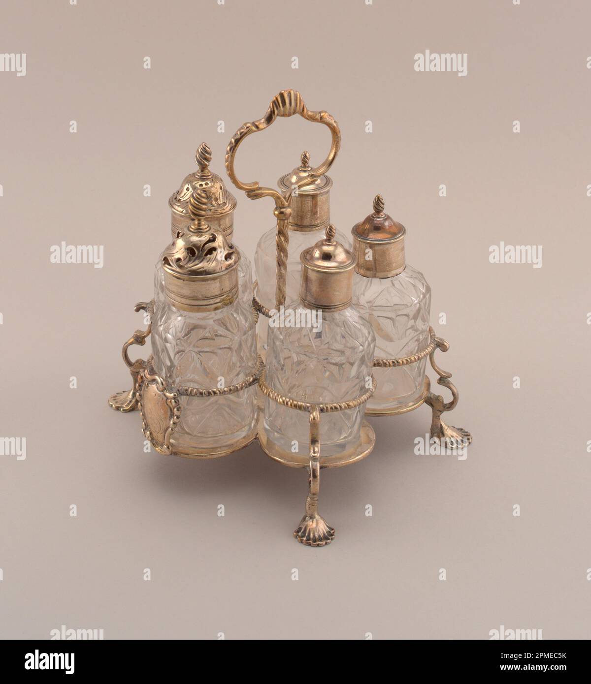 Cruet Set mit Standfuß (England); zugeordnet zu John Delmester; Silber, Glas; A: 17,5 x 16,5 cm (6 7/8 x 6 1/2 Zoll) b: 11 x 4 cm (4 5/16 x 1 9/16 Zoll) c: 11 x 4 cm (4 5/16 x 1 9/16 Zoll) t: 10,4 x 16,5 cm (4 1/8 x 6 1/2 Zoll) E: 9,5 x 4,1 cm (3 3/4 x 1 5/8 Zoll) f: 10 x 3,6 cm (3 15/16 x 1 7/16 Zoll) Stockfoto